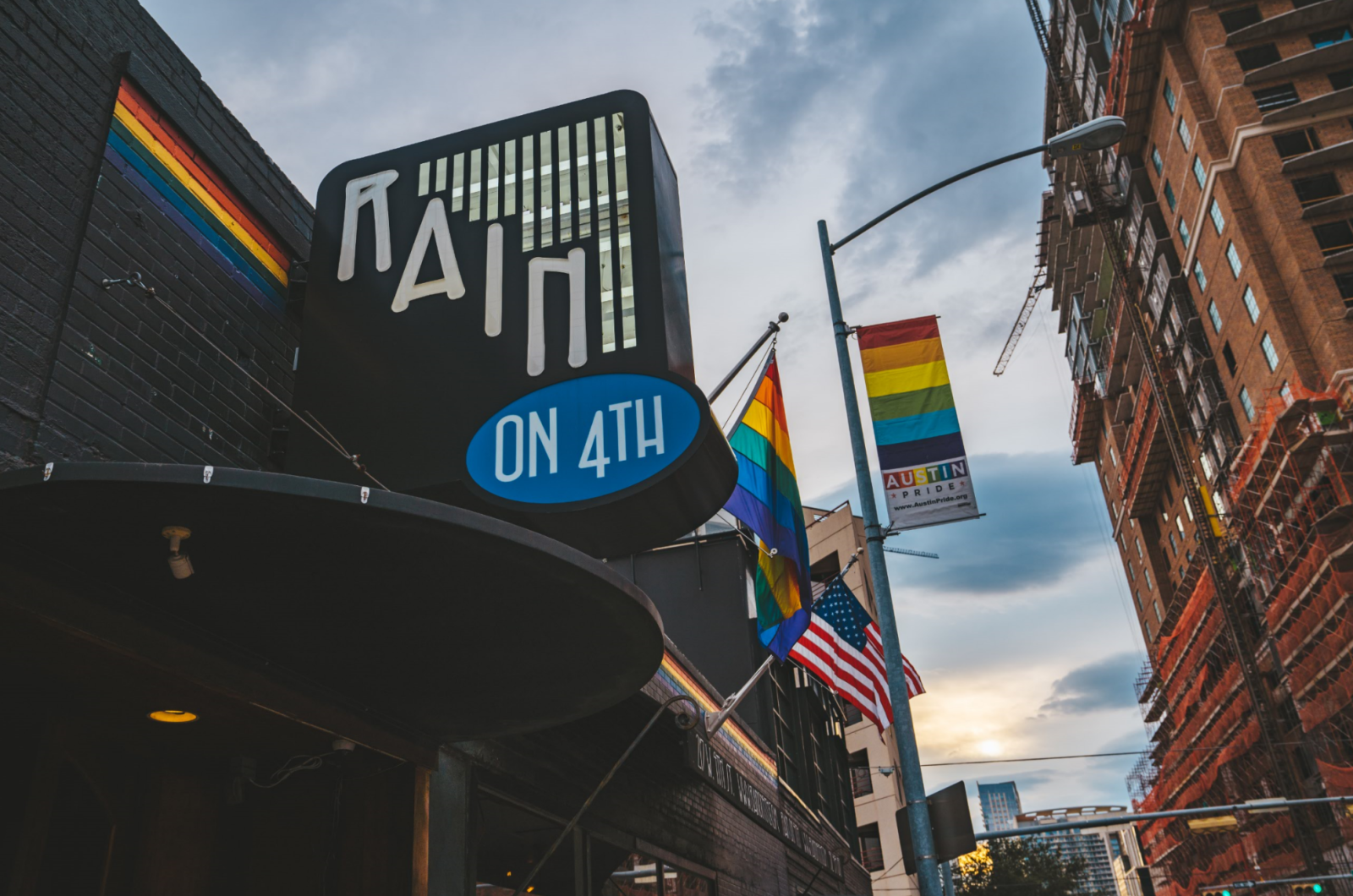 Rain on 4th marquee with Pride flags on Austin's Fourth Street