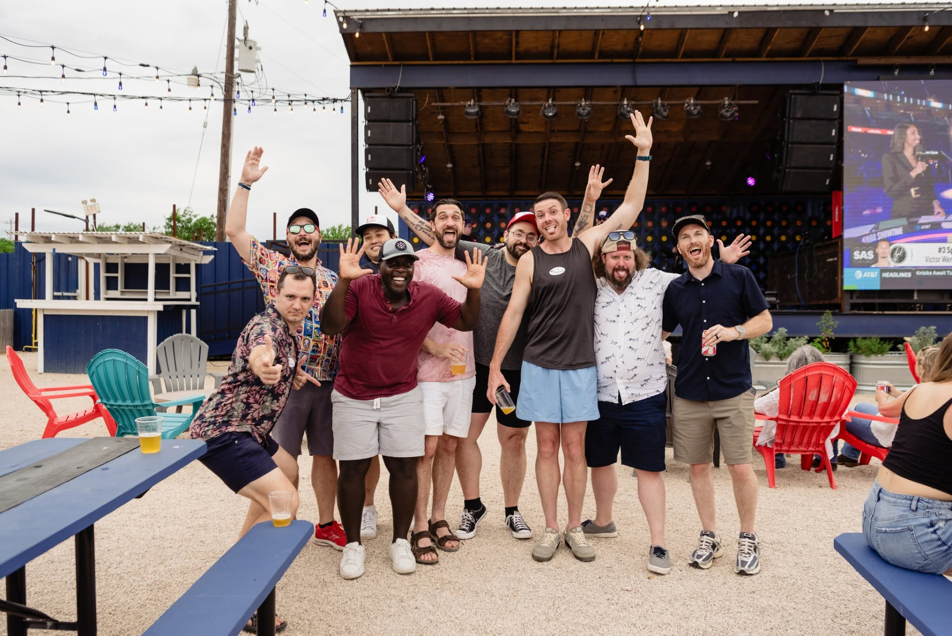 A group of guests cheering in front of the Drinks Backyard stage
