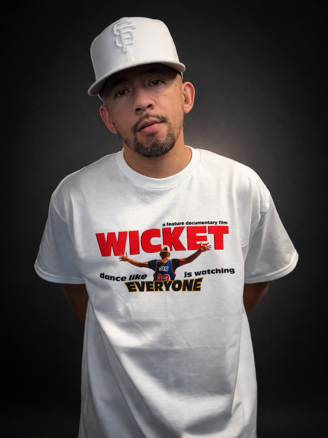 Gabriel 'Bboy Wicket' Jaochico in a white SF cap and a WICKET documentary t-shirt, studio portrait