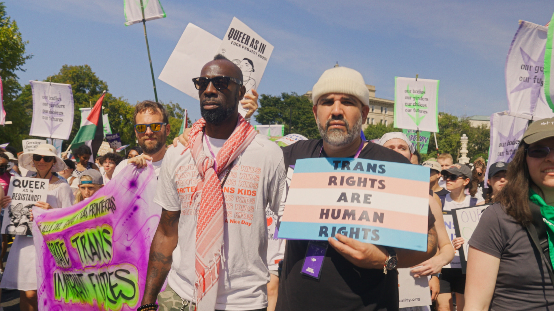 Stephen, Christoph and Carlos at the Gender Liberation March holding a 'Trans Rights Are Human Rights' sign