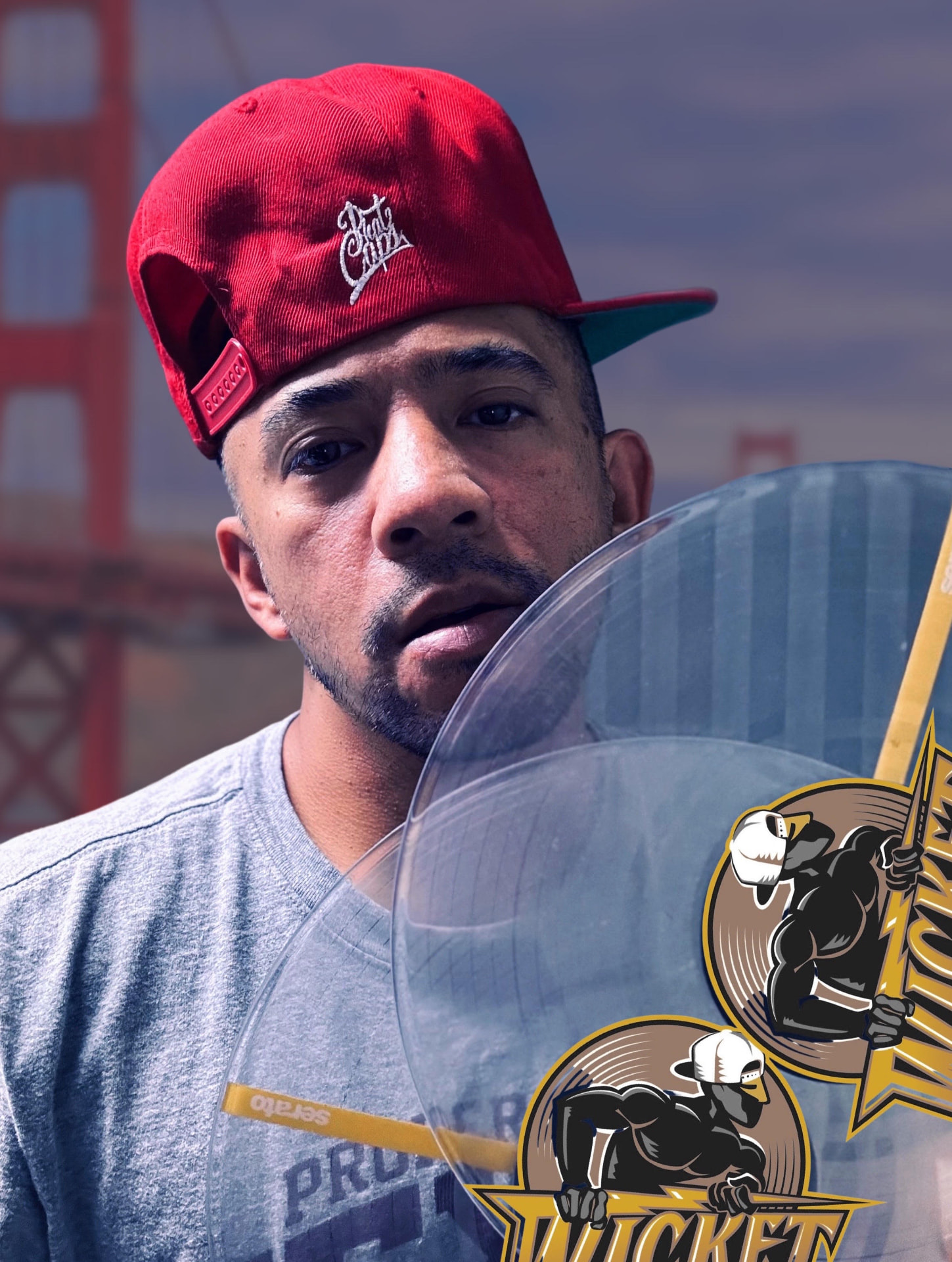 Gabriel 'Bboy Wicket' Jaochico in a red cap holding a clear Wicket-branded vinyl record