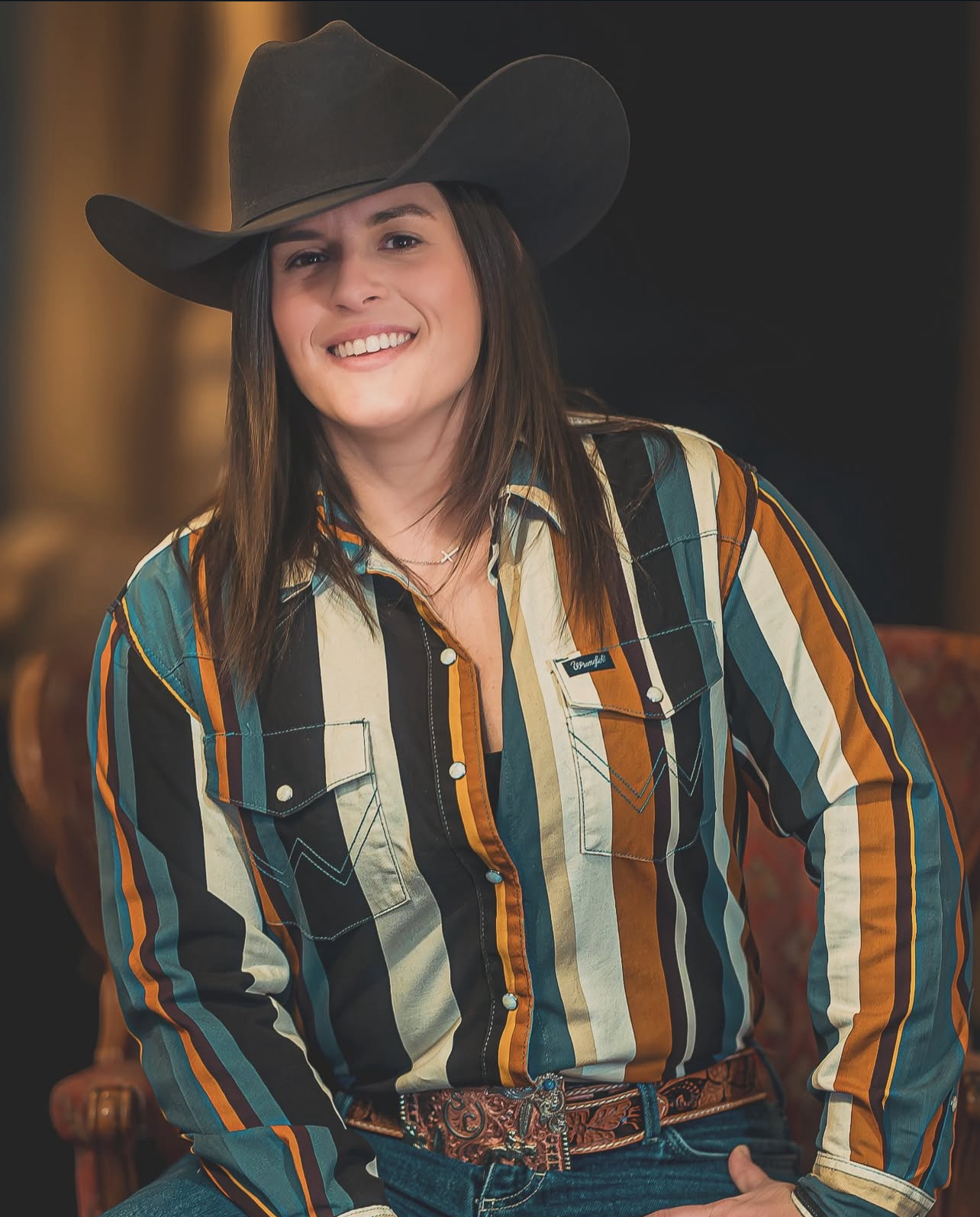 Steph Cash in a cowboy hat and striped shirt