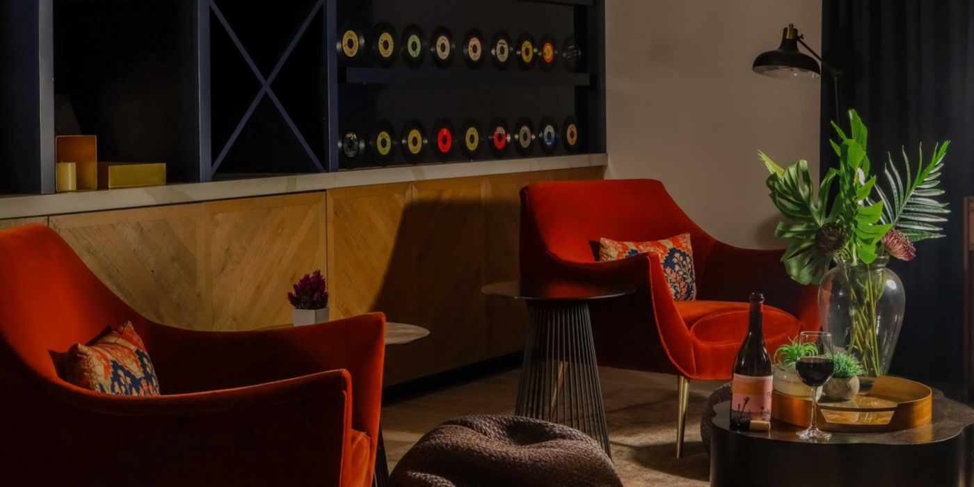 Warmly lit lounge with burnt-orange velvet armchairs at Hotel Indigo Austin Downtown