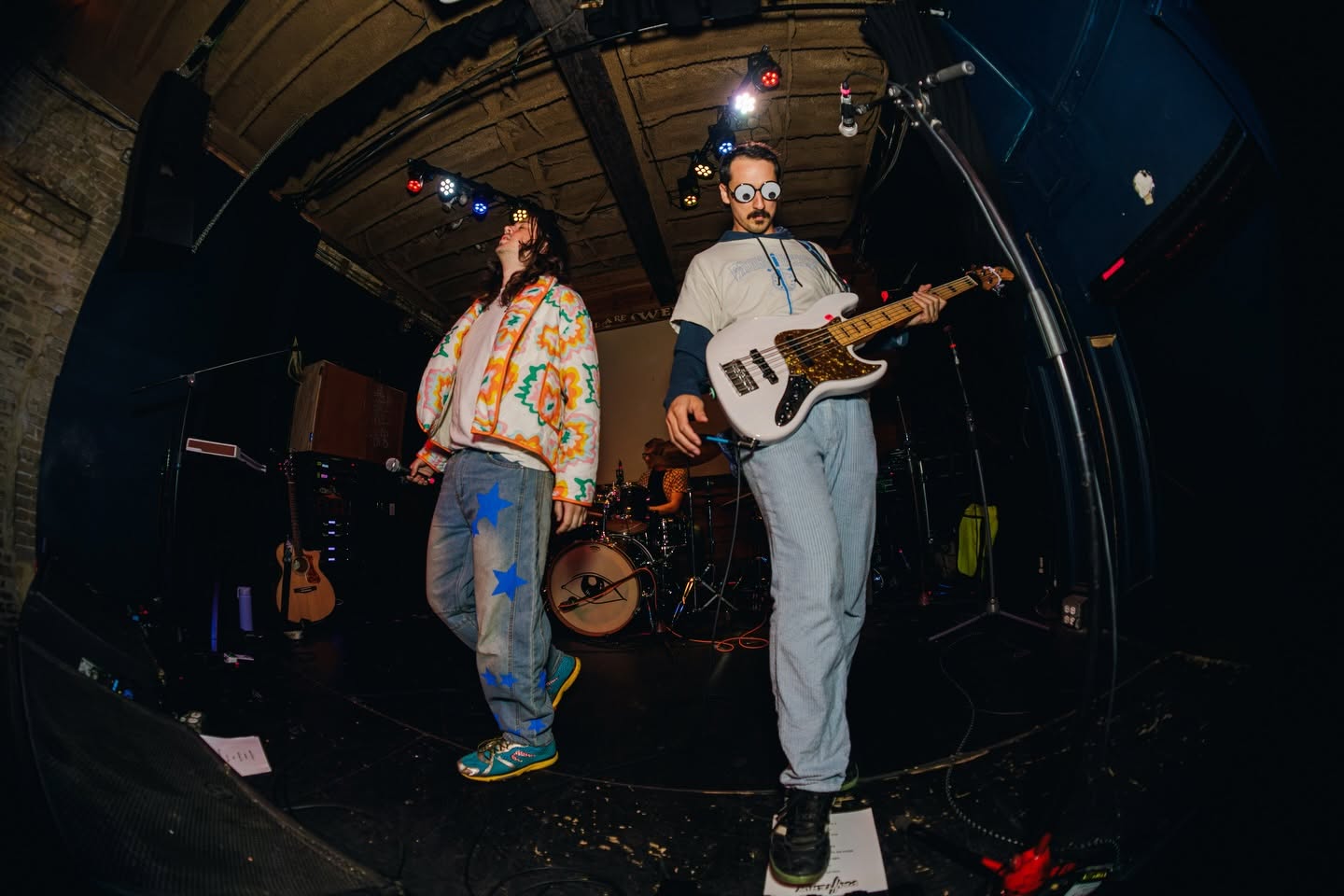 Painterly performing live on a dark club stage in fisheye view