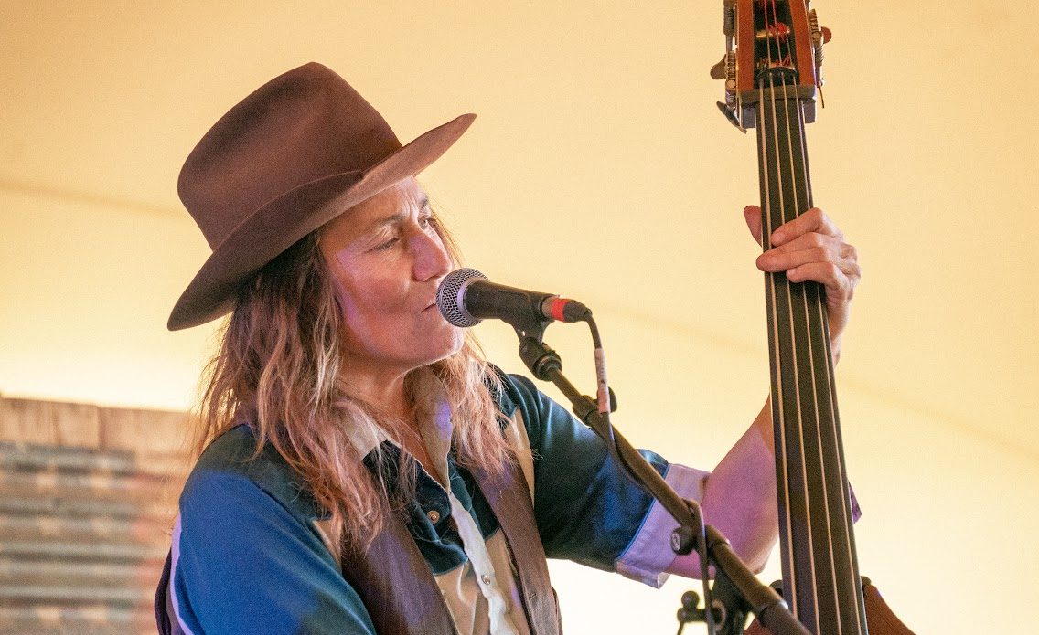Melissa Carper singing while playing upright bass on stage